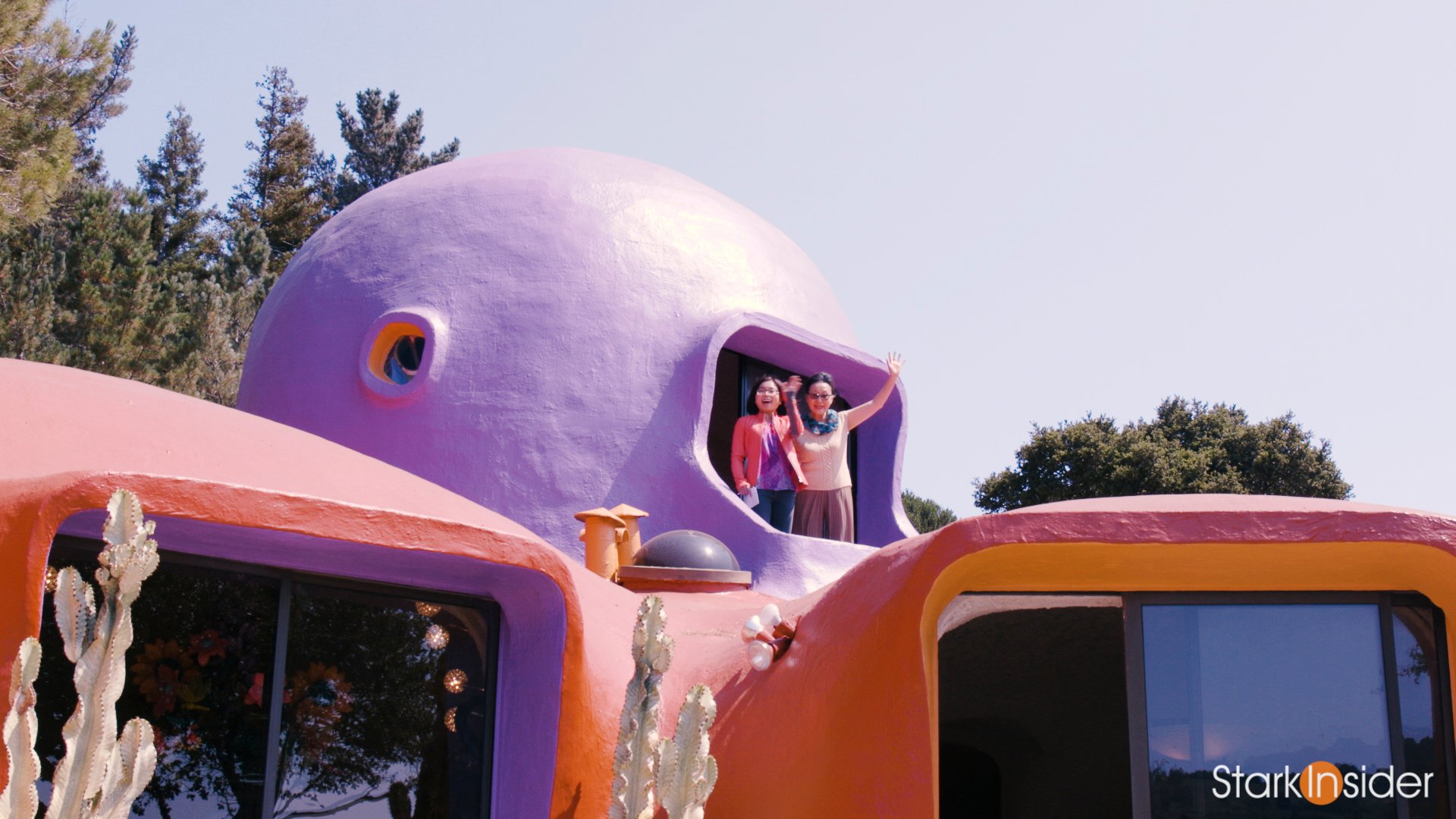 Florence Fang and Loni Stark waving from the Flintstone House rooftop - Hillsborough, California